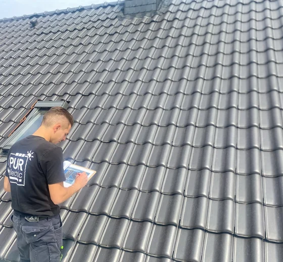 Mitarbeiter plant Photovoltaikanlage auf Dach